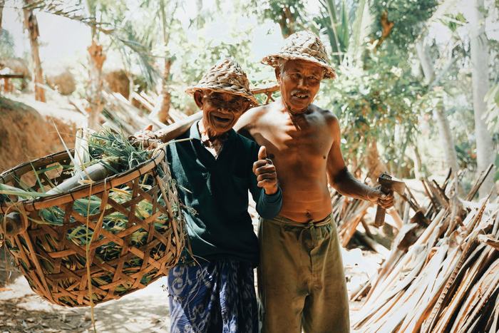 Two Balinese elders in woven hats